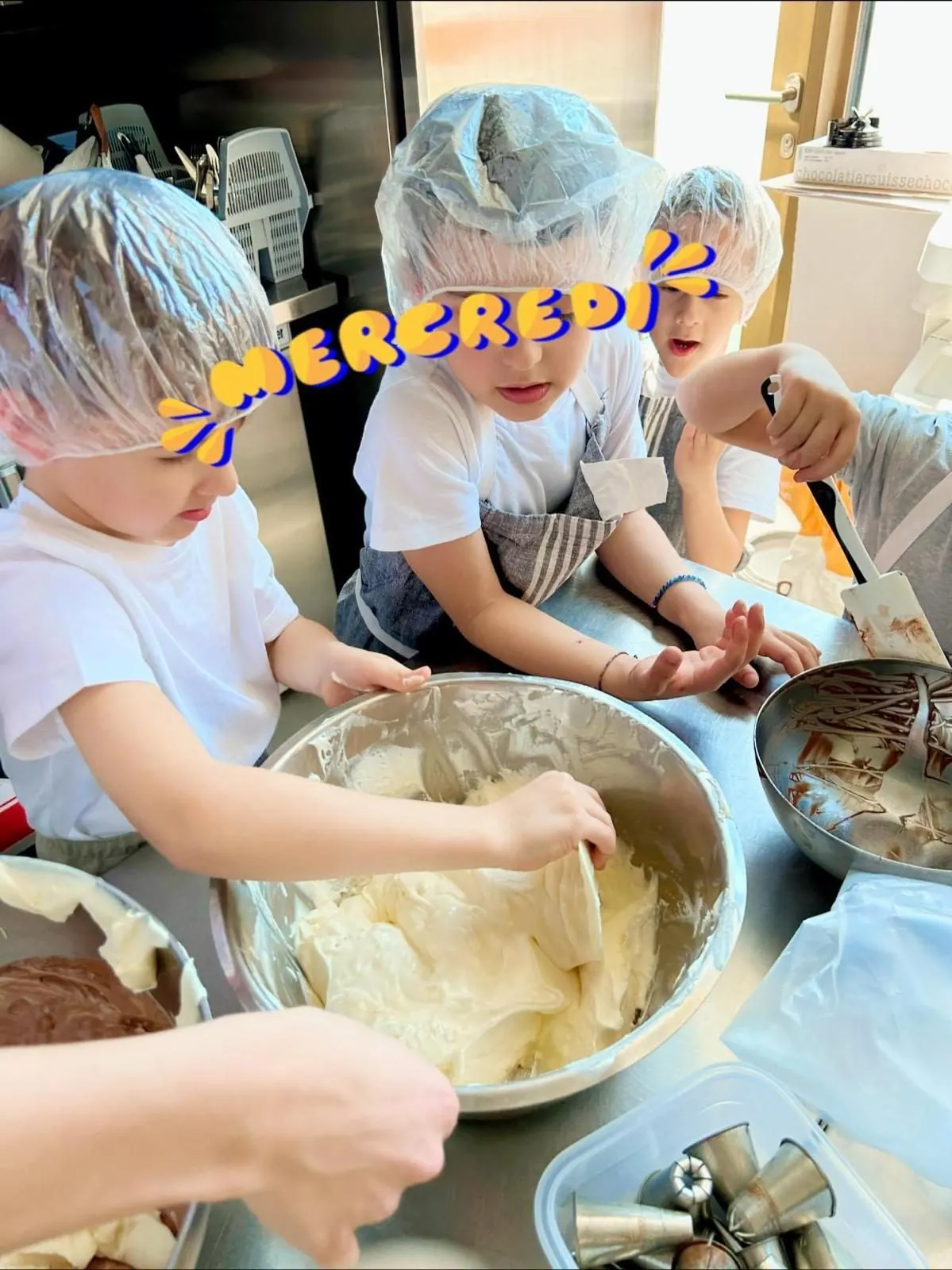 Enfants en toque qui mélangent la pâte lors d'un atelier du mercredi