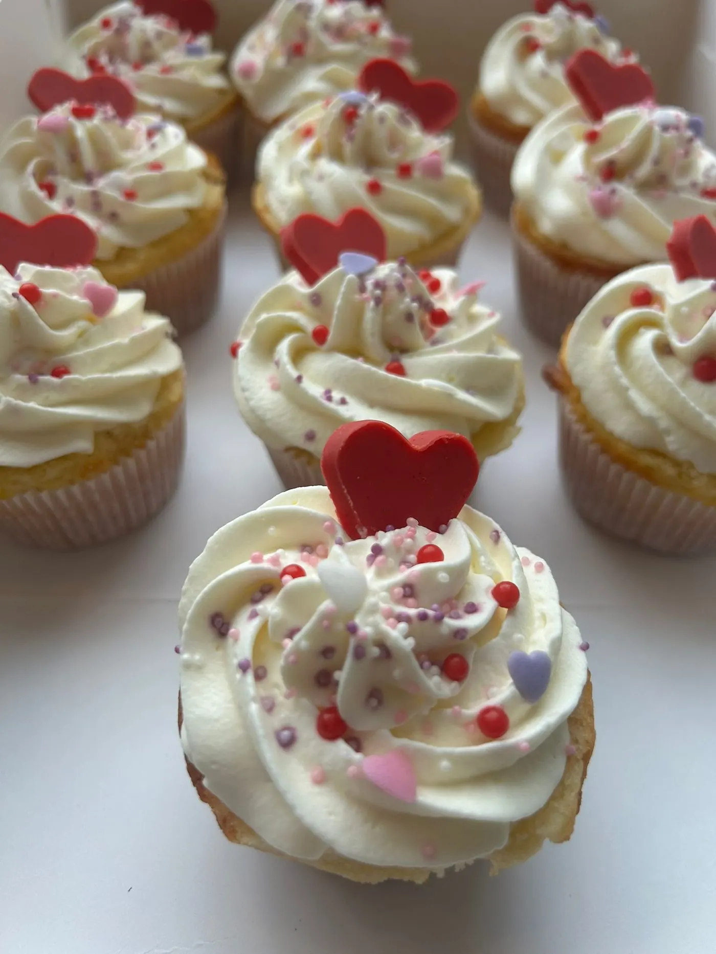 Valentinstags-Cupcakes mit Chantilly und roten Herzen
